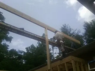 Carpenter setting a ridge beam over a new addition frame — Ice Dam Removal by Roofing Brothers in Lavinia