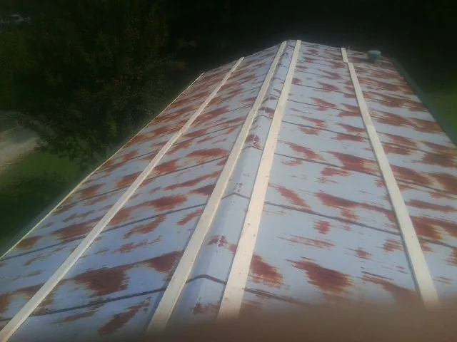 Rusted metal roof panels with new wood purlins before replacement — Storm Damage Roof Repair in Lavinia by Roofing Brothers