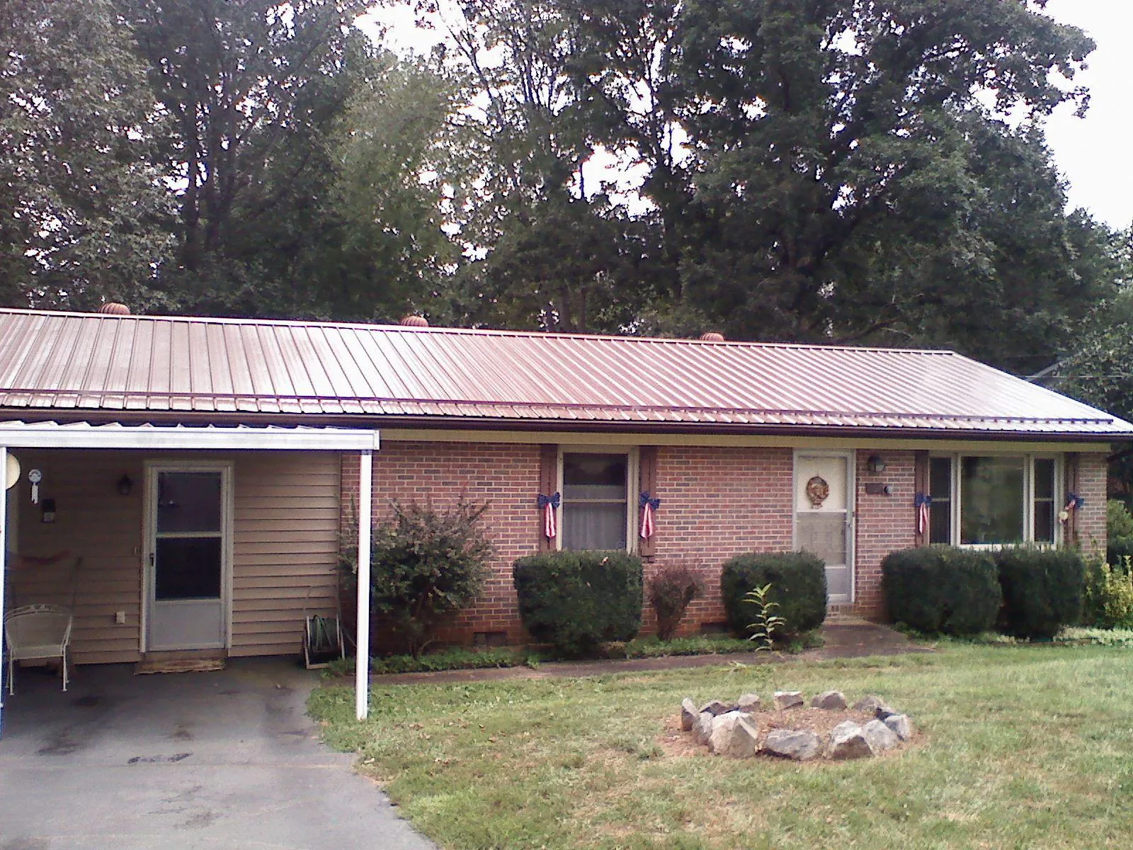 Bronze metal roof and carport on a brick ranch home — Roof Repair work by our crew in Lavinia